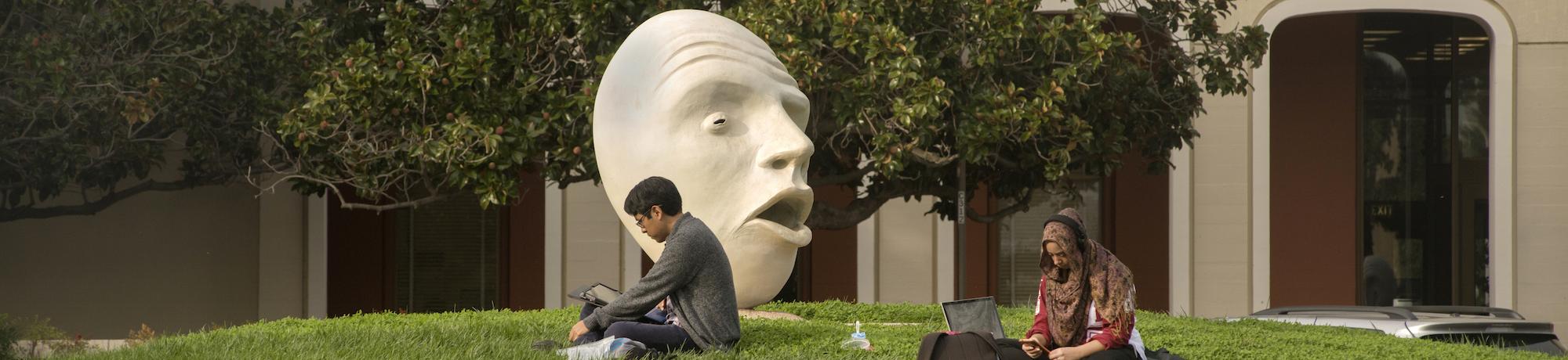 students stugying near a campus egg head
